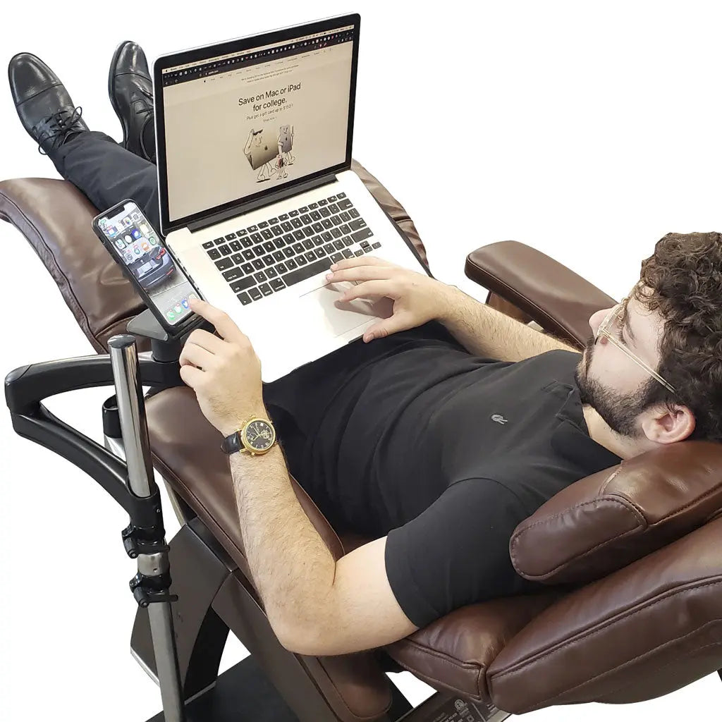 A man using the Ergonomic Laptop and Tablet Stand while reclining in a recliner.