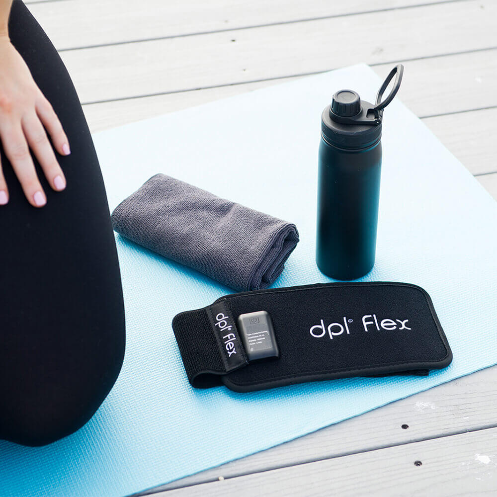 dpl® Back and Body Flex Pad on a yoga mat with a small grey towl and black water bottle.