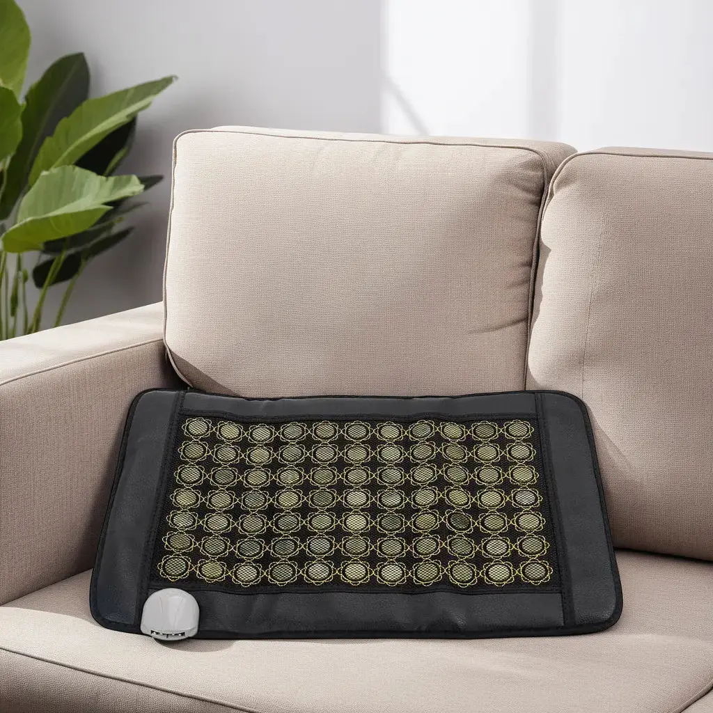 Far Infrared Heating Pad on a beige sofa with a plant in the back.