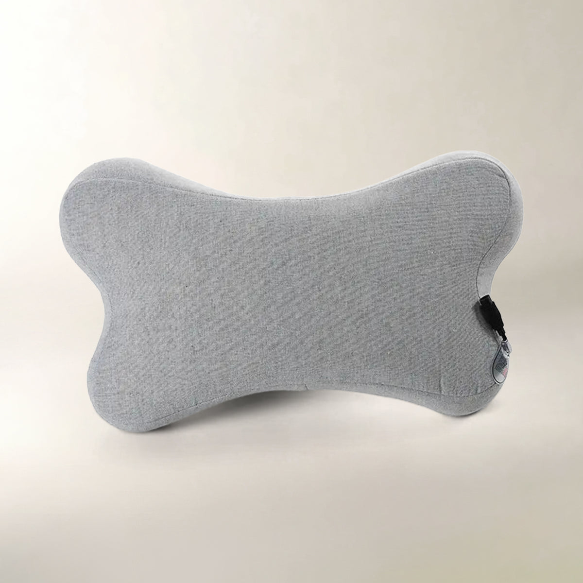 A light gray bone-shaped massage cushion made of textured fabric, shown on a neutral cream background.
