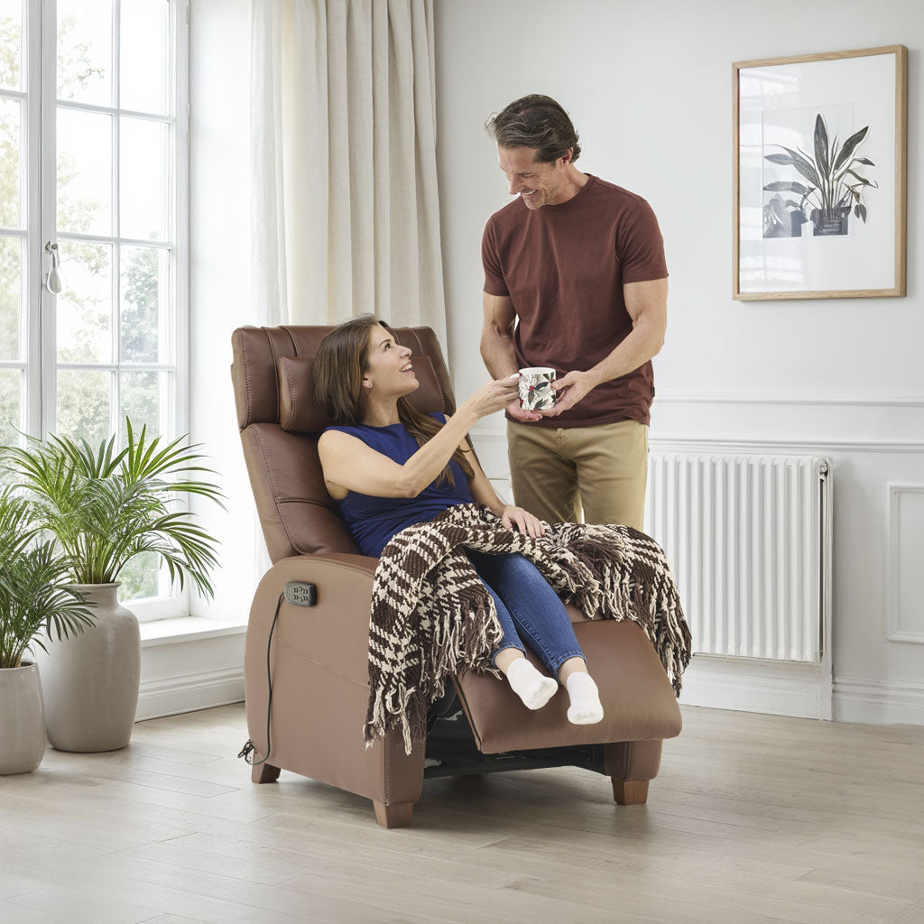 Man and woman in a living room with a brown recliner chair.