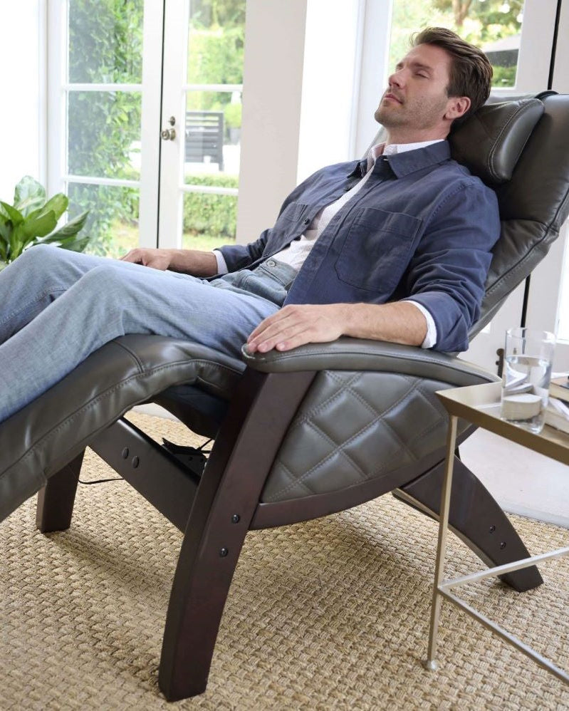 A man sitting in a recliner in front of a window