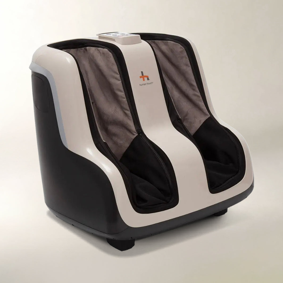 A modern foot massage machine with a black and off-white plastic shell, dark gray fabric inner sleeves, and black foot compartments, shown on a neutral light gray background.