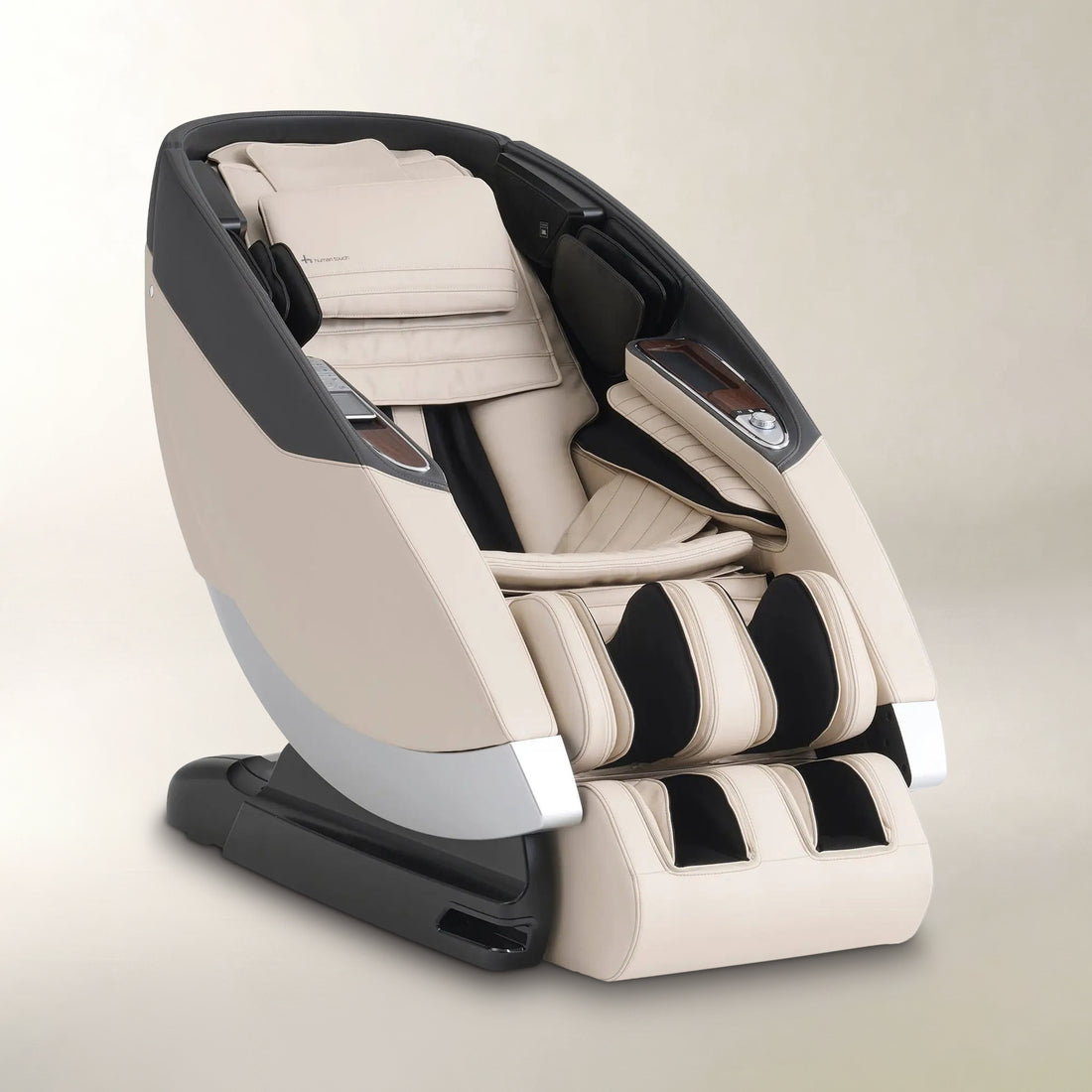 A modern massage chair in beige and black, shown at a three-quarter angle on a neutral beige background.