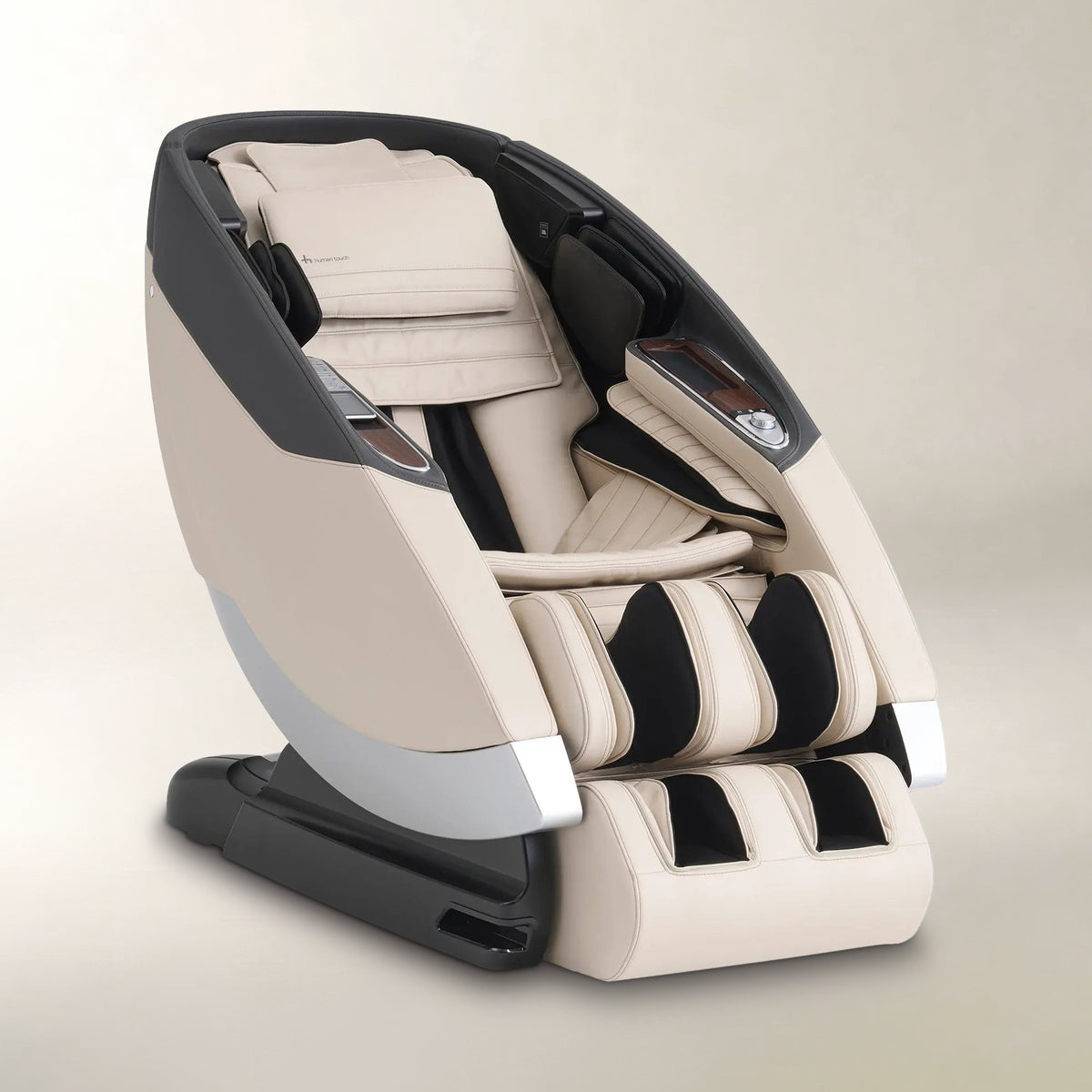 A modern massage chair in beige and black, shown at a three-quarter angle on a neutral beige background.