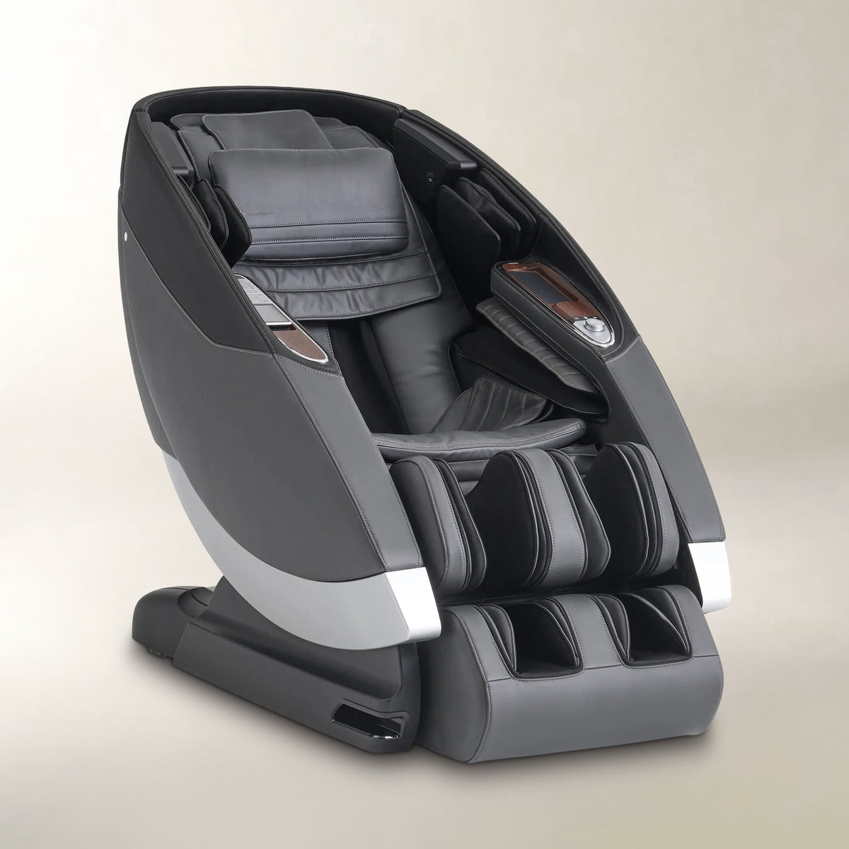 A modern gray and black massage chair with silver accents, shown from a three-quarters angle on a neutral beige background.