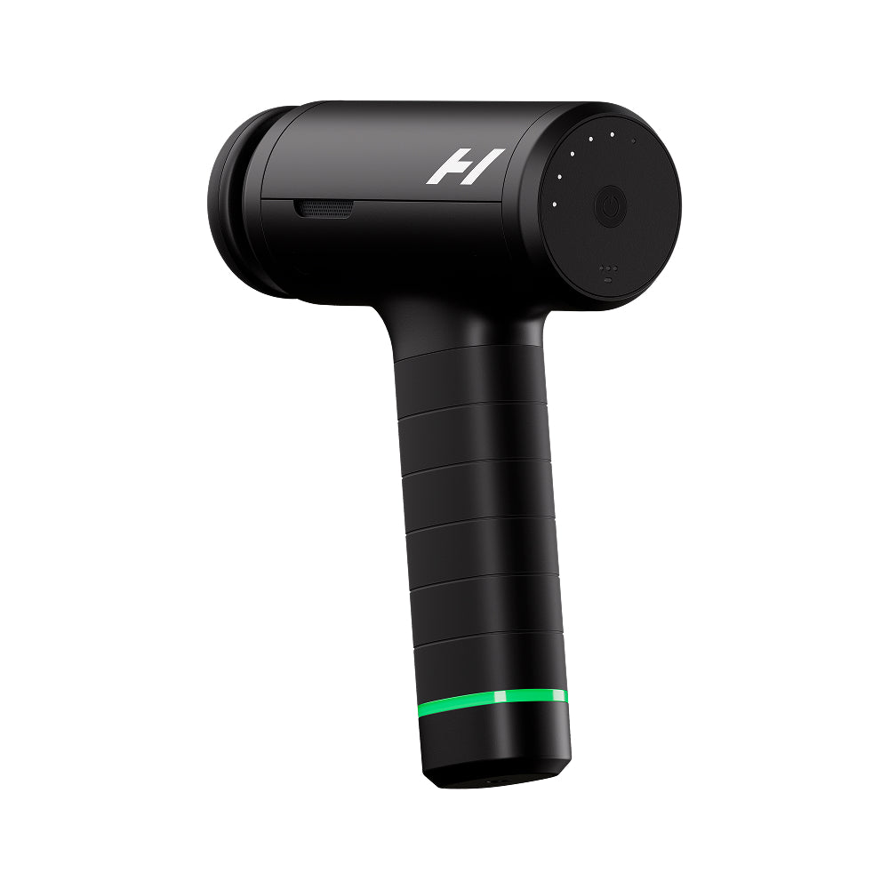 A black handheld T-shaped massage gun with a textured grip, a white stylized 'H' logo on the head, and a glowing green indicator light near the base, shown against a solid white background.