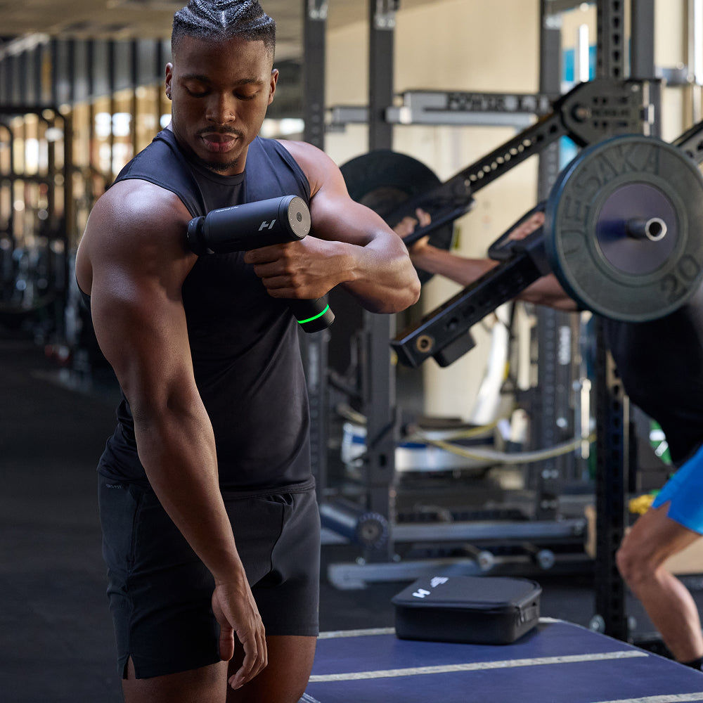 Man usiong the Hypervolt 3 Pro Massager in a gym setting