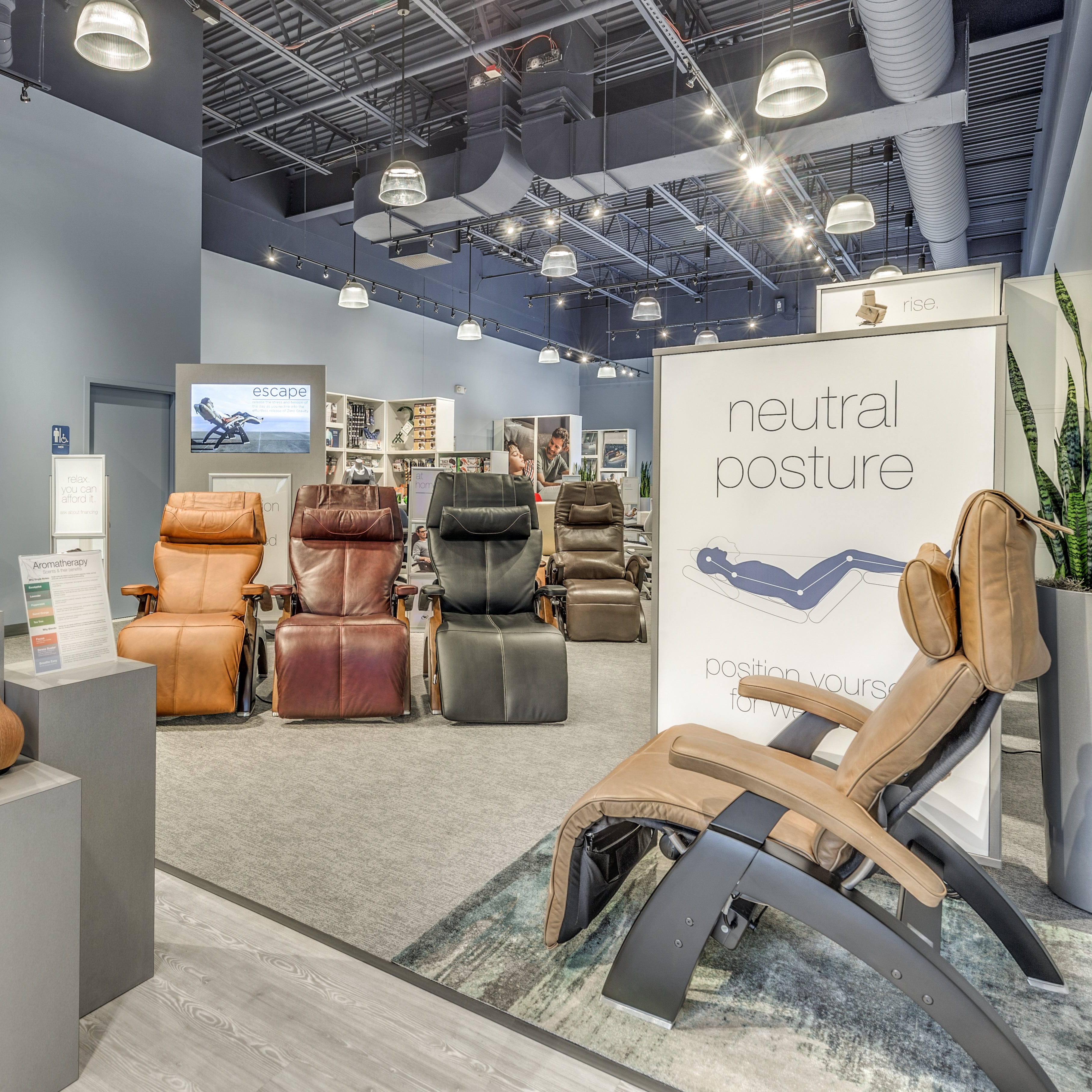 Recliner chairs in a showroom with 'neutral posture' sign