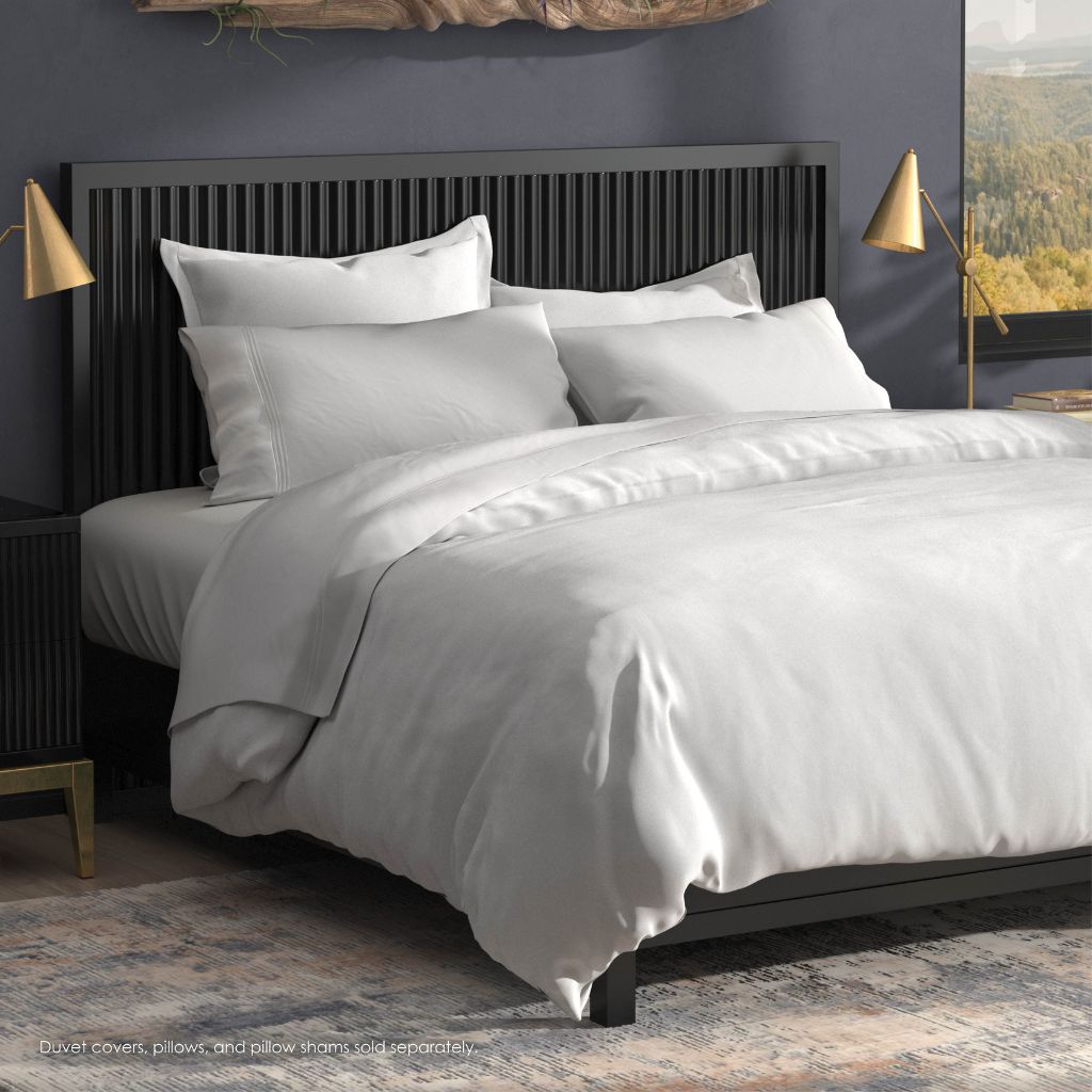 Bed with white bedding and pillows in a bedroom setting
