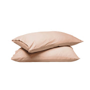 Two plain pillowcases stacked on a white background, in a soft warm beige or blush-tan tone.