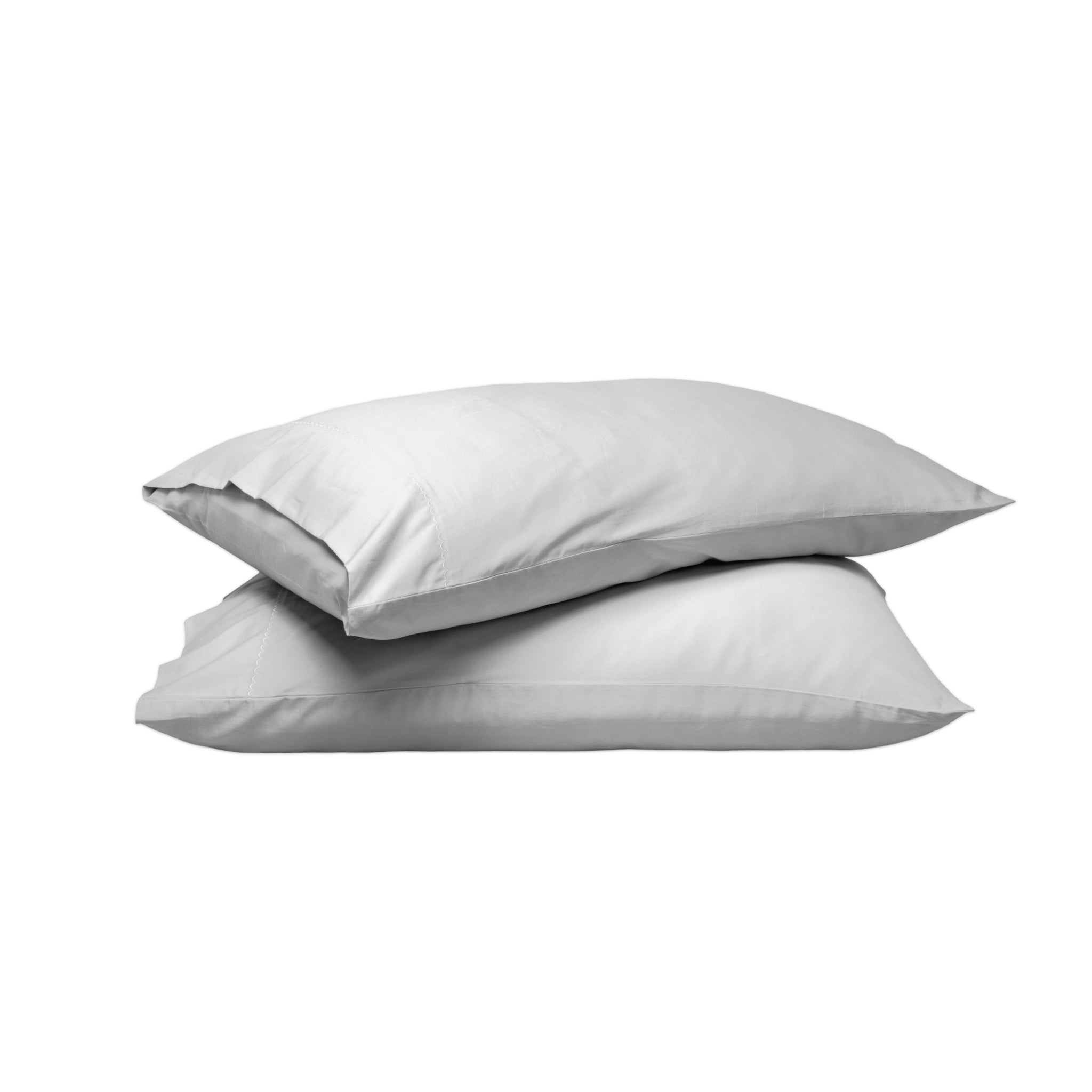 Two plain white pillows stacked on top of each other against a solid white background.