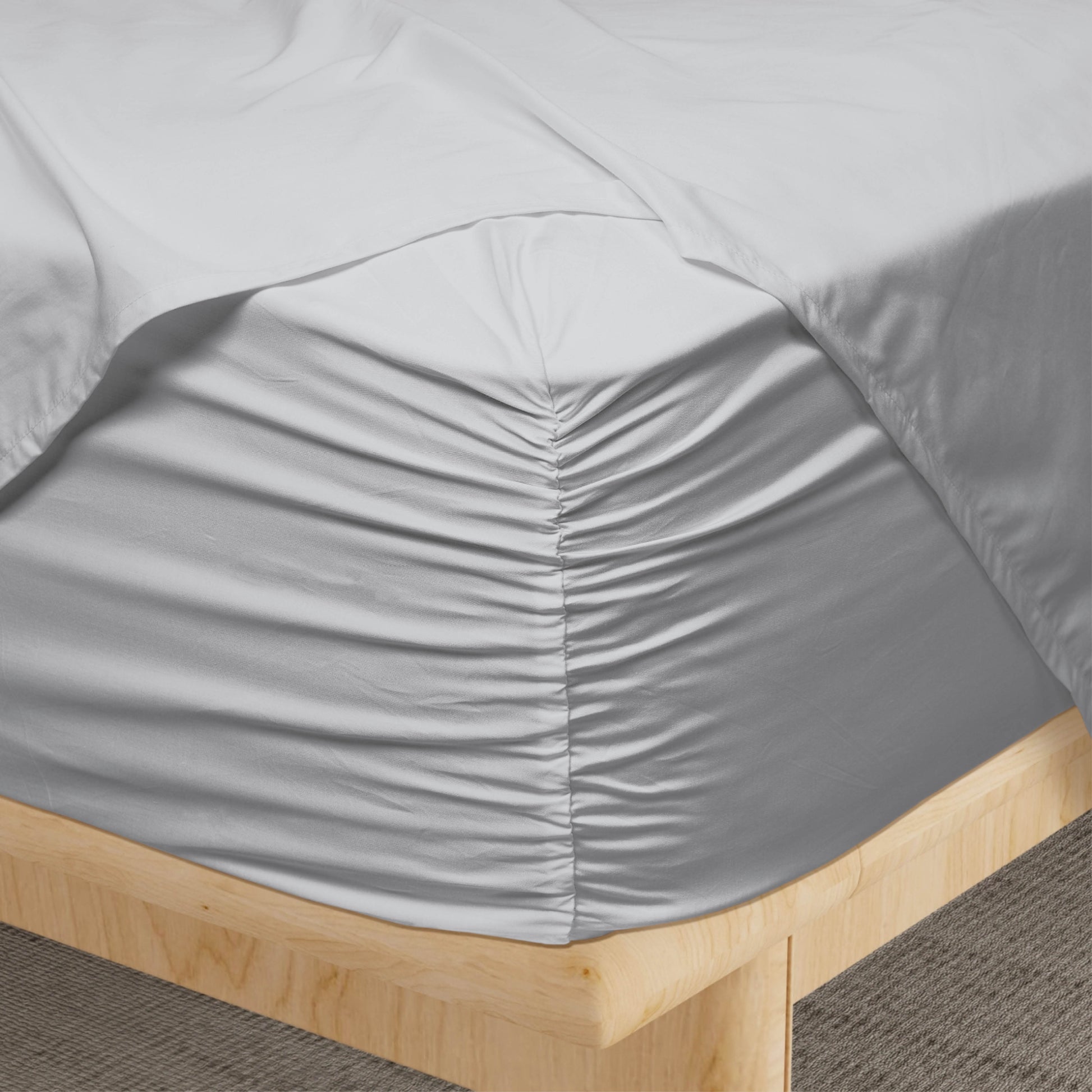Gray fitted sheet on a wooden bed frame