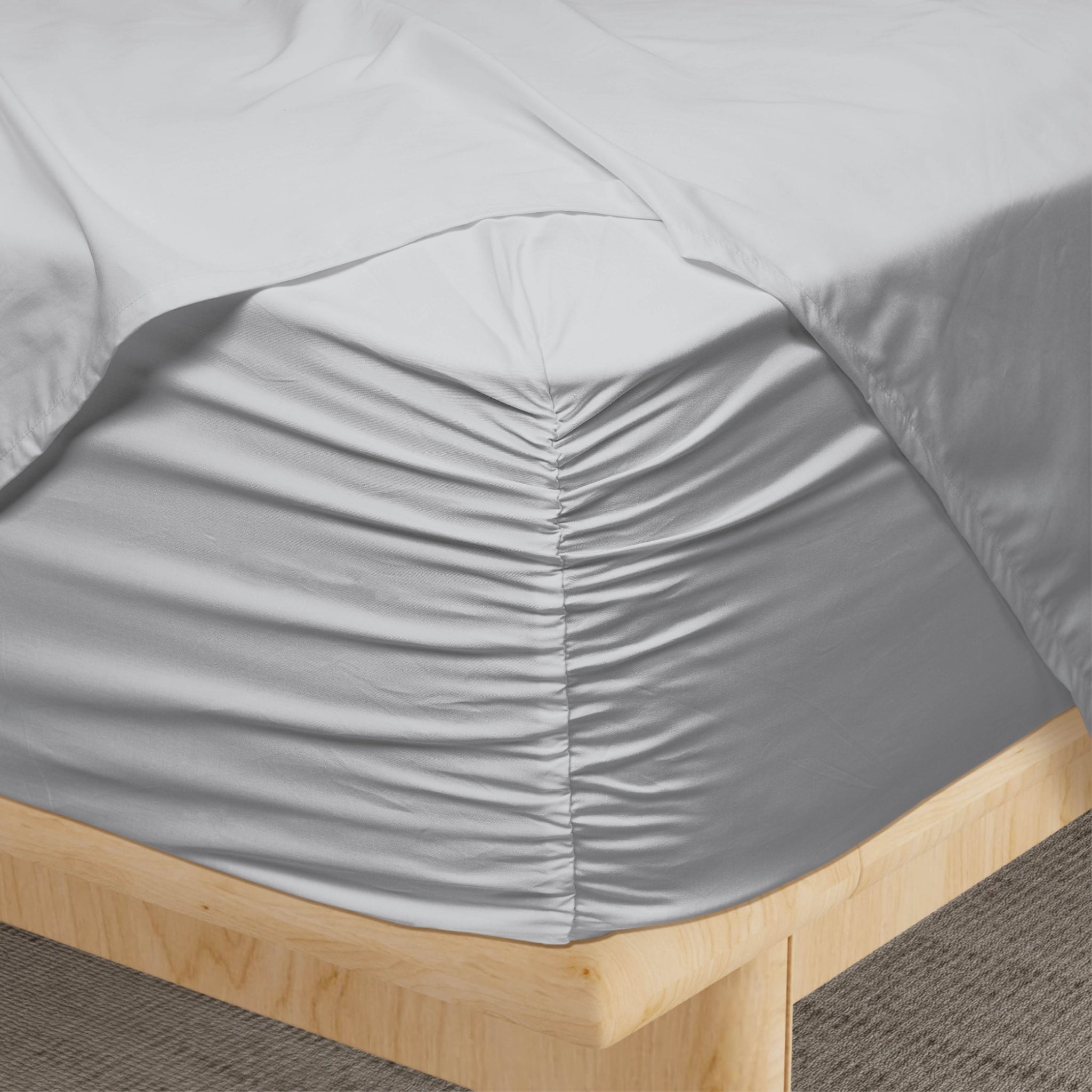 Gray fitted sheet on a wooden bed frame