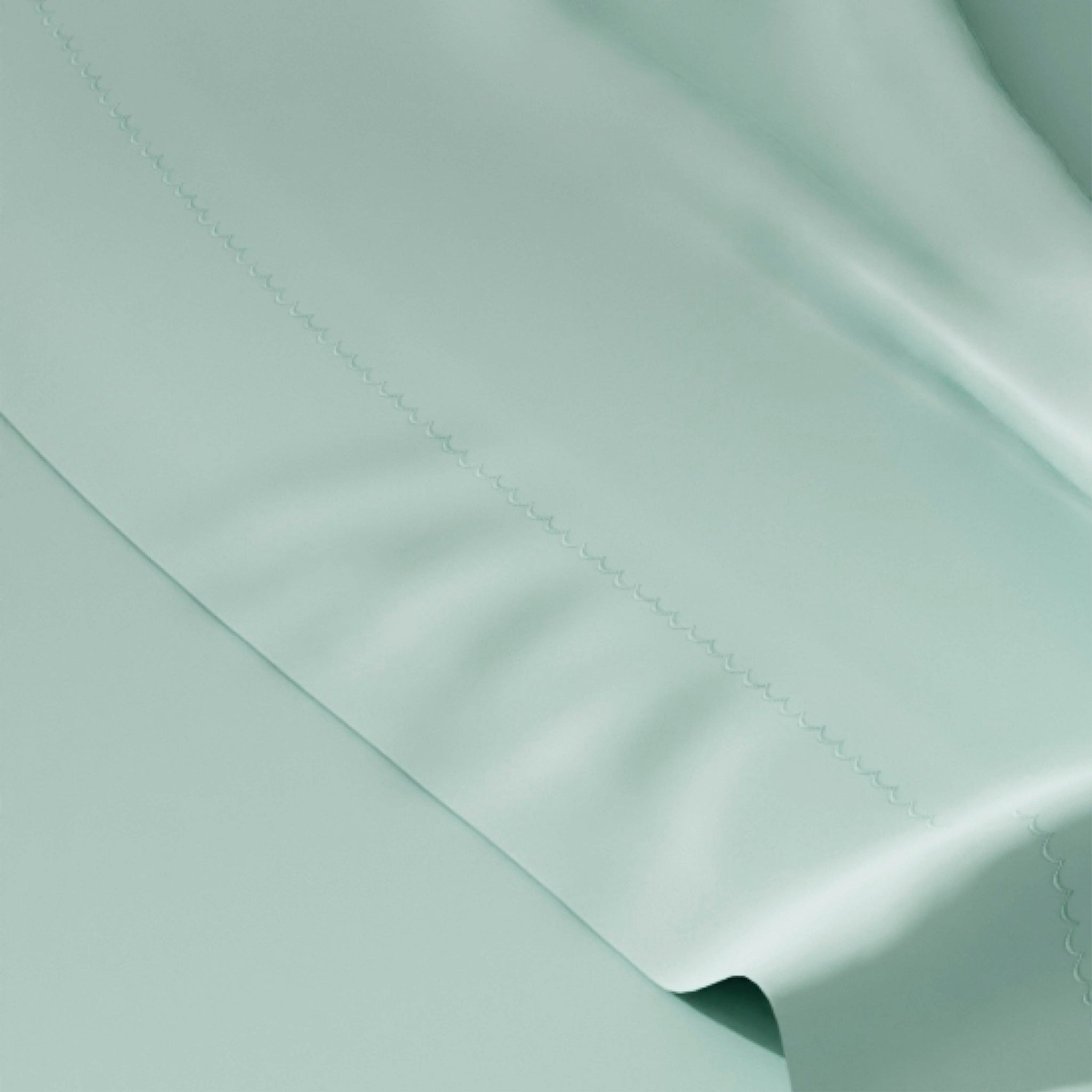 A close-up of a mint green satin or silk-like fabric with a subtle sheen and fine stitched detail along a fold.