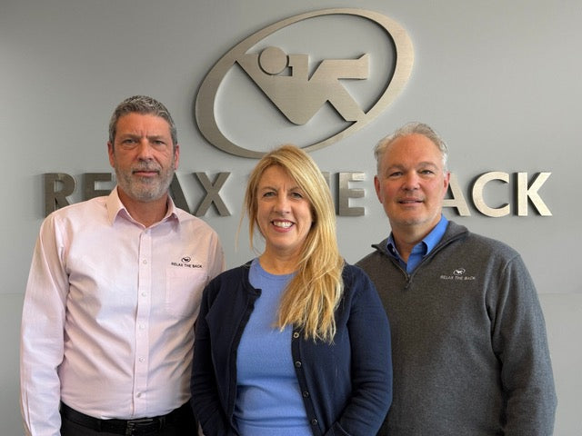 Three people standing in front of a 'Relax Reclack' logo on a wall.