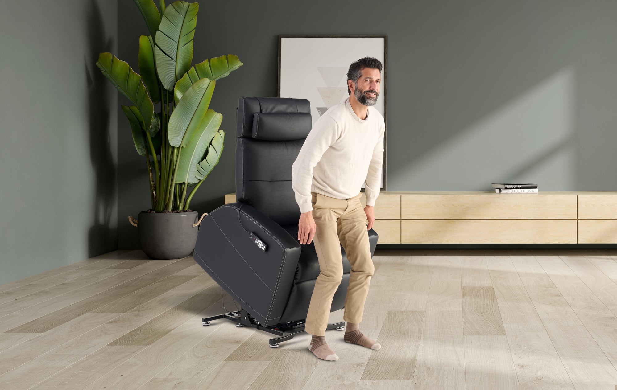 Man standing next to a recliner chair in a modern living room.