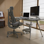 Ergonomic chair in front of a desk with computer setup in a modern office.