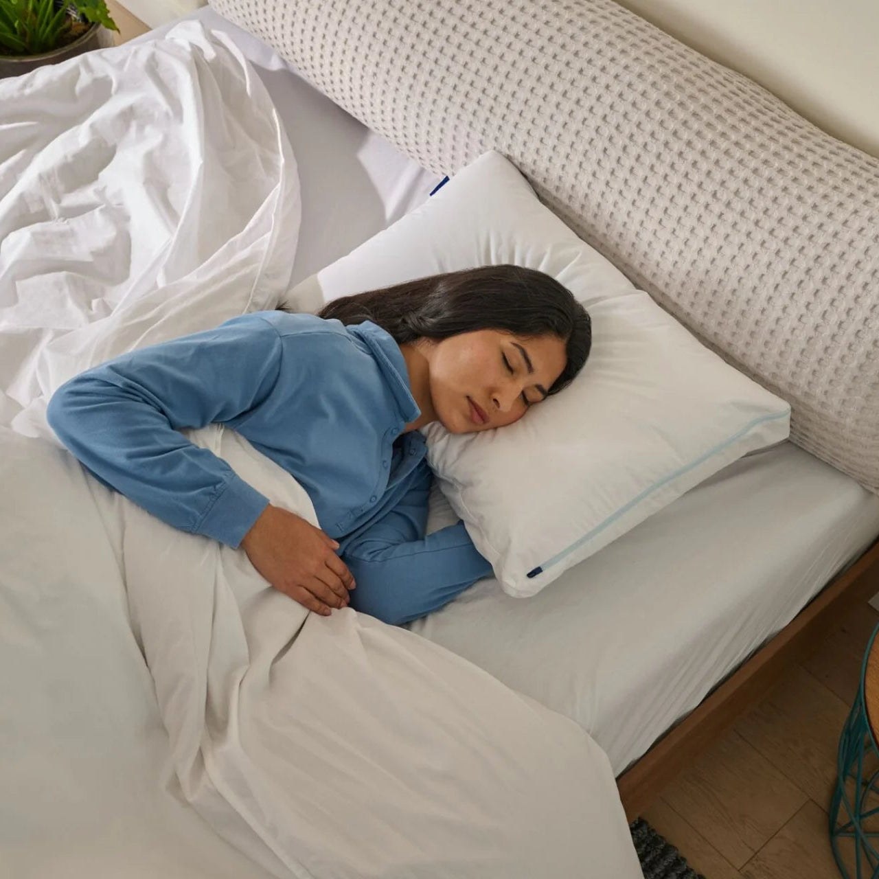 Woman sleeping on a bed with a pillow and comforter
