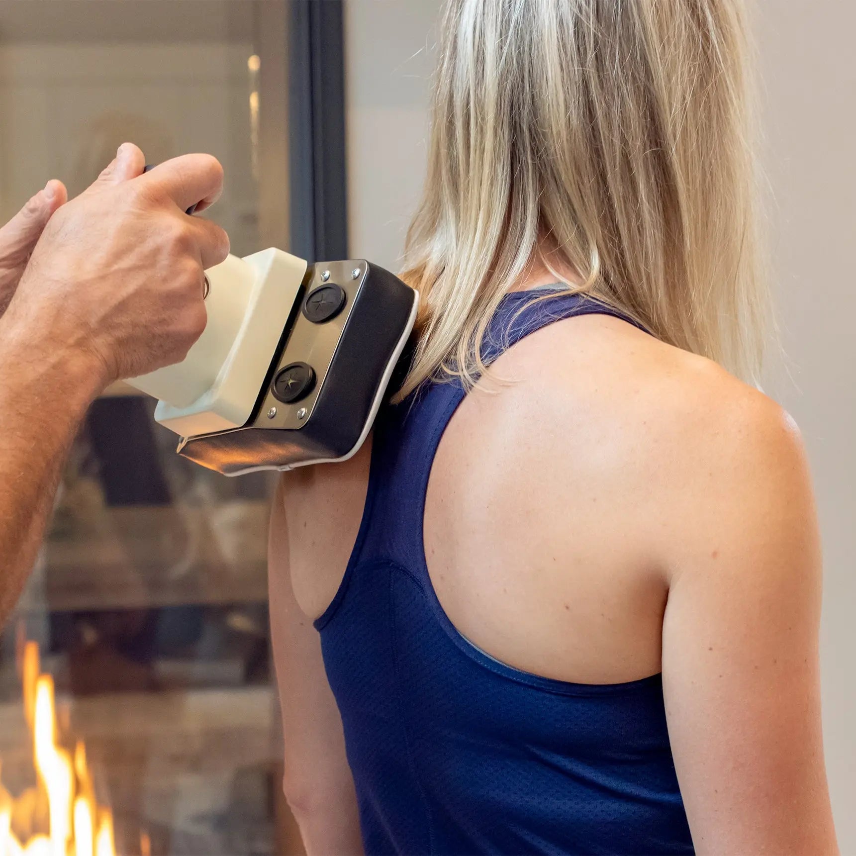 Oscillatory Body Massager being used on a woman's shoulder blades.
