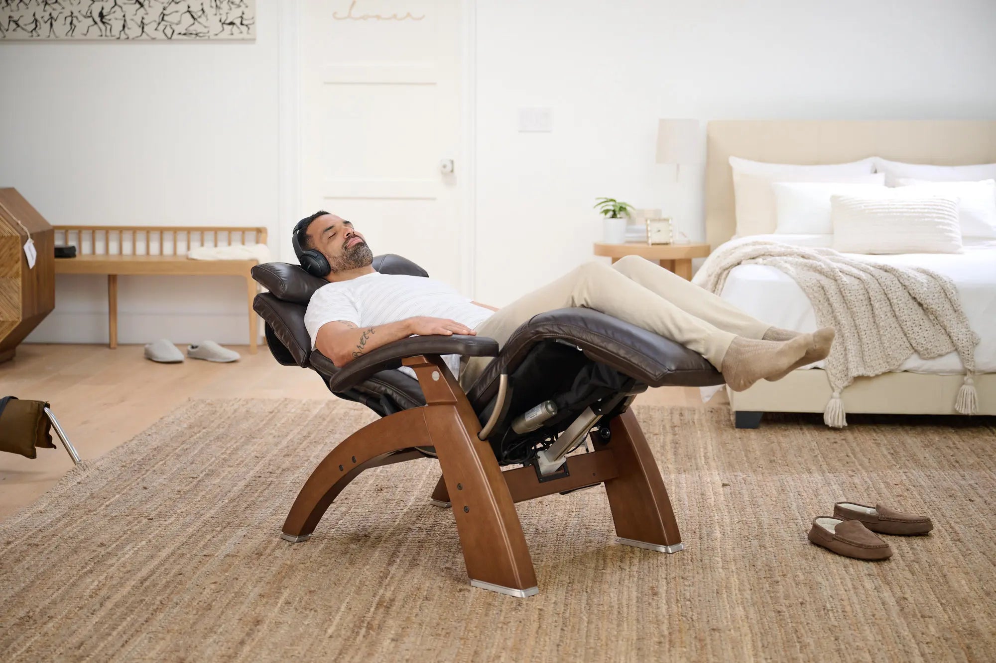Man relaxing in a massage chair in a bedroom setting