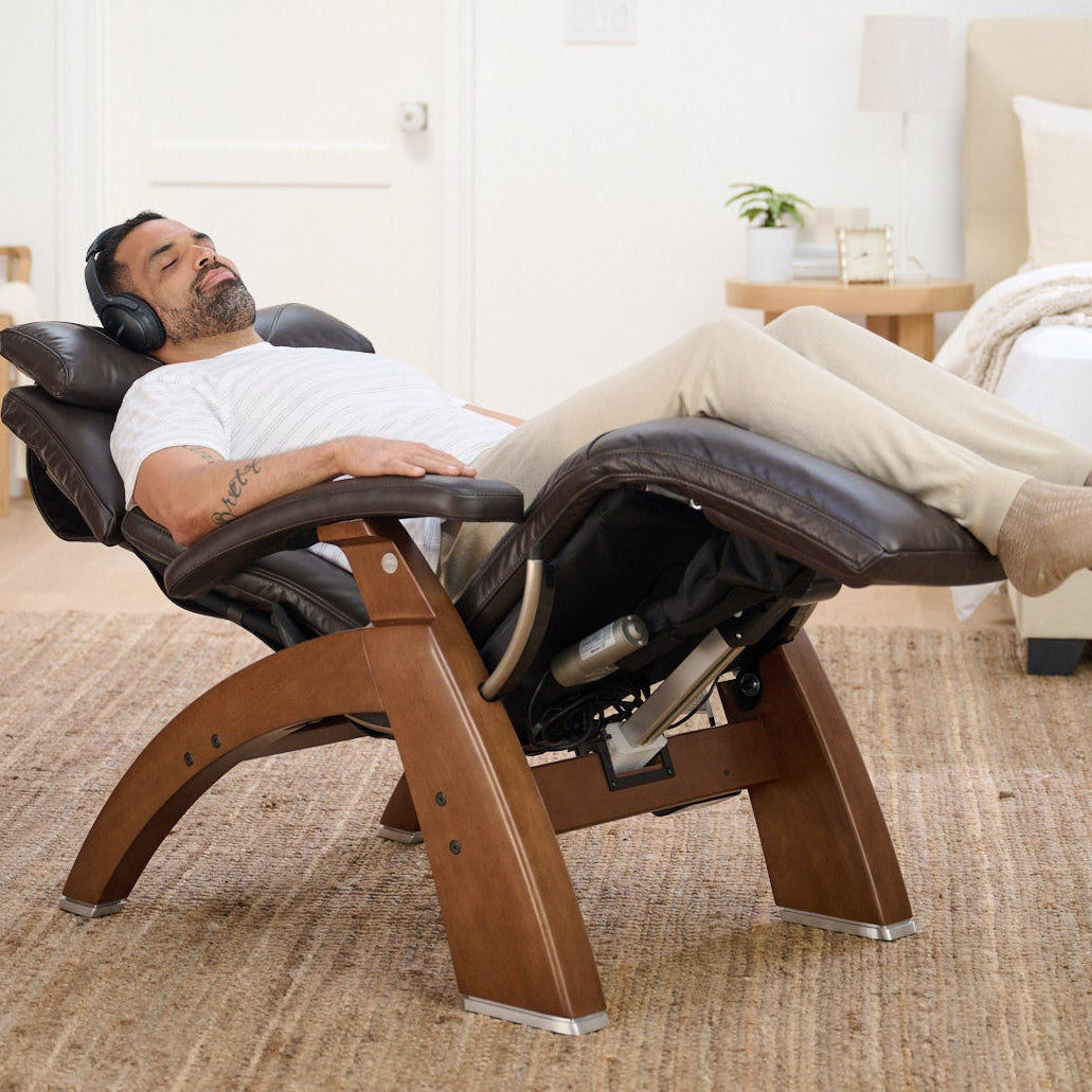 Man relaxing on a modern lounge chair in a bedroom setting.