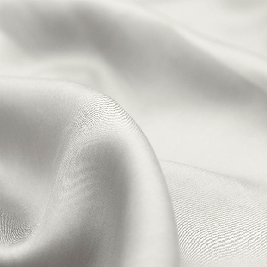 Close-up of white satin fabric with soft folds