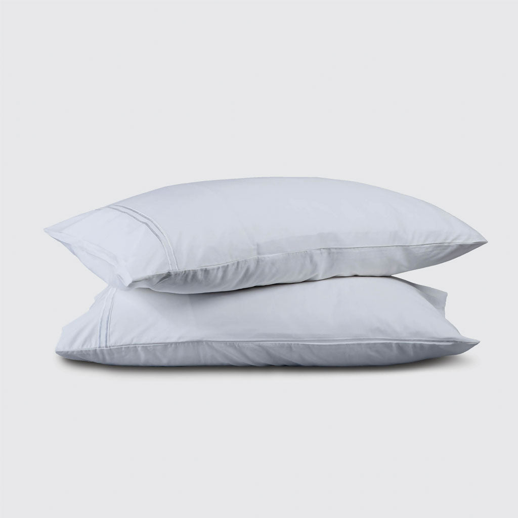 Two light blue pillows stacked on a white background