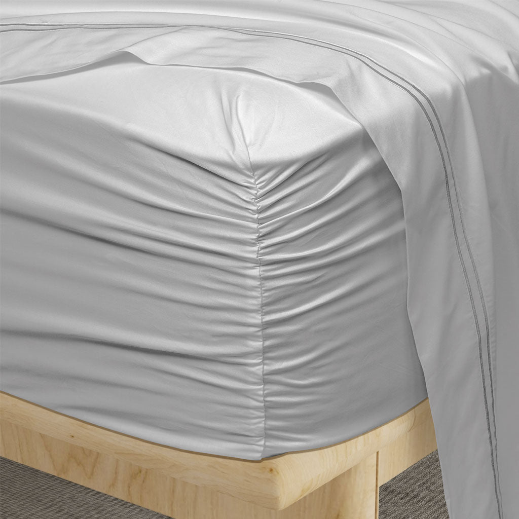 Gray fitted sheet on a wooden bed frame