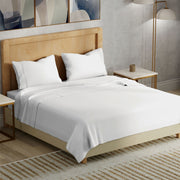 Neatly made bed with white bedding in a modern bedroom setting.