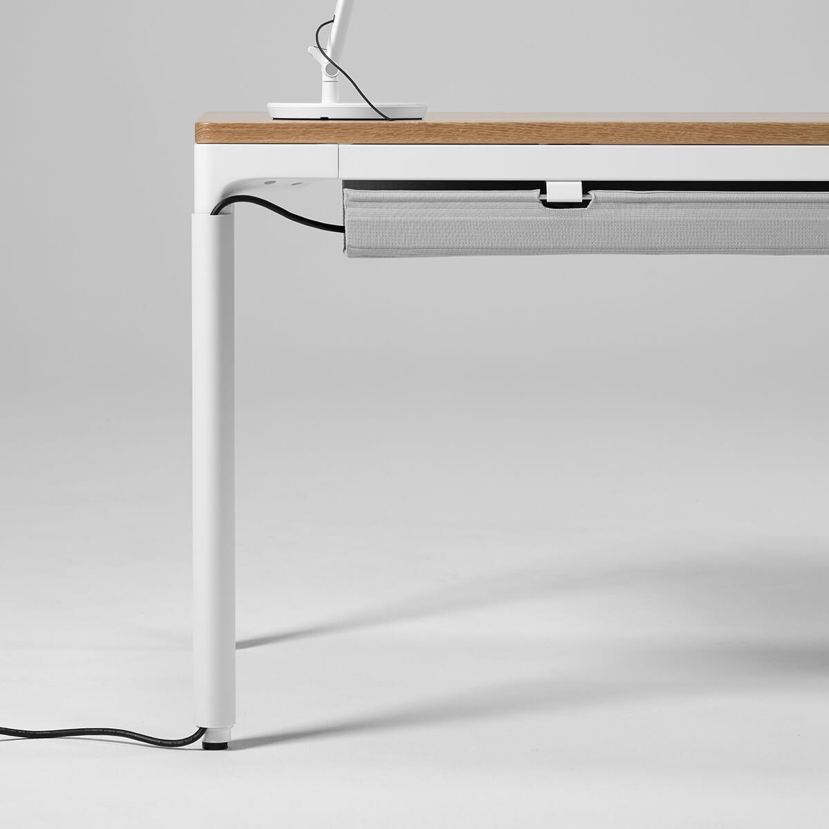 Modern desk with a white frame and wooden surface on a light gray background