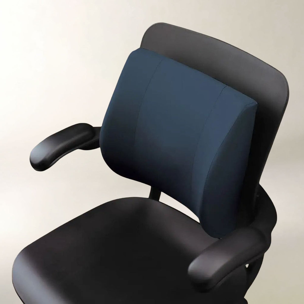 A dark navy blue ergonomic office chair cushion mounted on a black office chair, shown against a plain light beige background.
