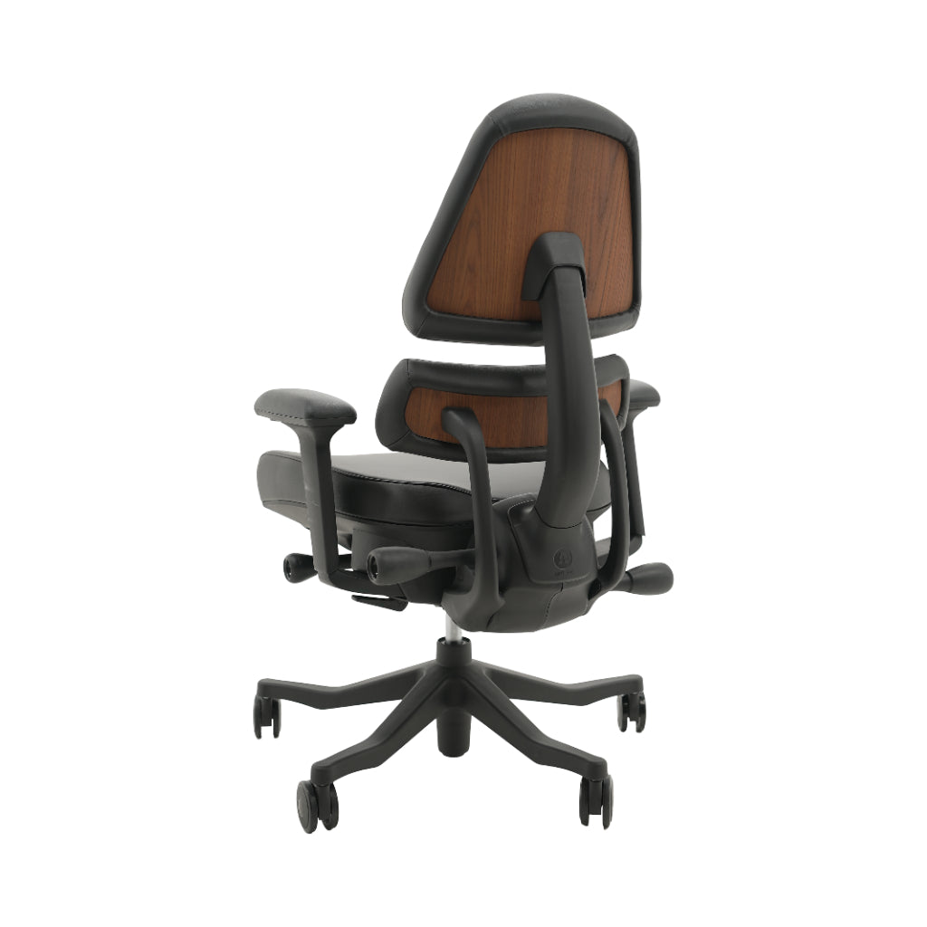 An ergonomic office chair with a high back, adjustable armrests, and a four-wheel base, shown from a rear angle on a white background.