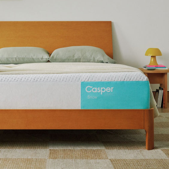 Casper mattress on a wooden bed frame with a side view.
