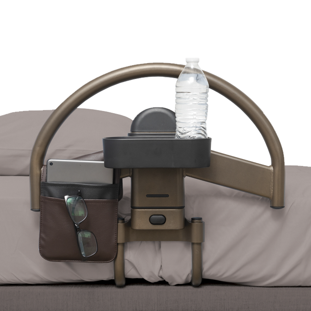 Bedside table with cup holder, phone stand, and water bottle on a bed.