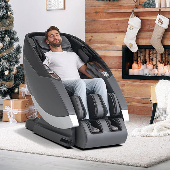Man relaxing in a massage chair in a cozy living room with Christmas decorations.