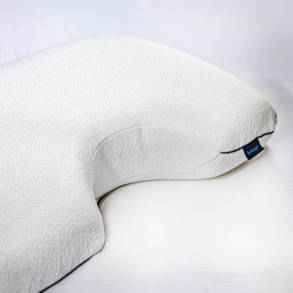 White neck pillow with a brand label on a white background