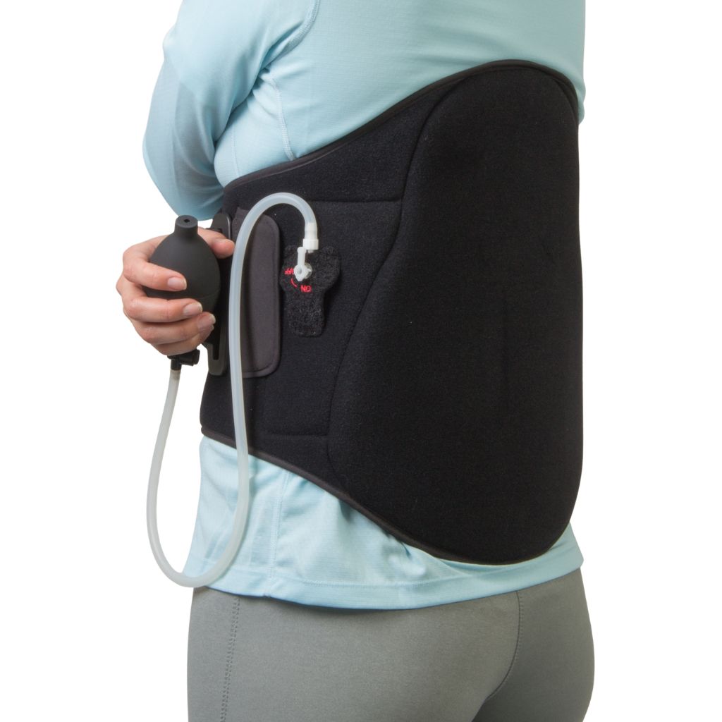 A person wearing a black high back support brace with an attached clear tube and black pump bulb, shown from the back against a white background.