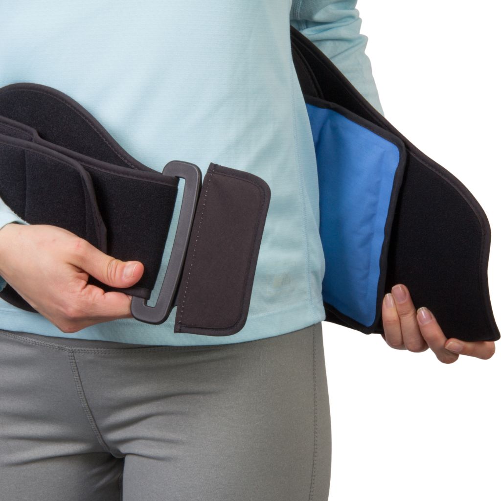 A person wearing a light blue top and gray pants holds a black high back support brace with a gray buckle and a blue inner lining against a white background.