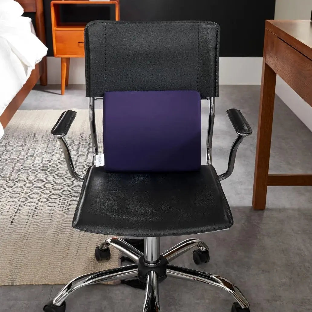 The Travel Lumbar Cushion shown in a bedroom setting on an office chair.