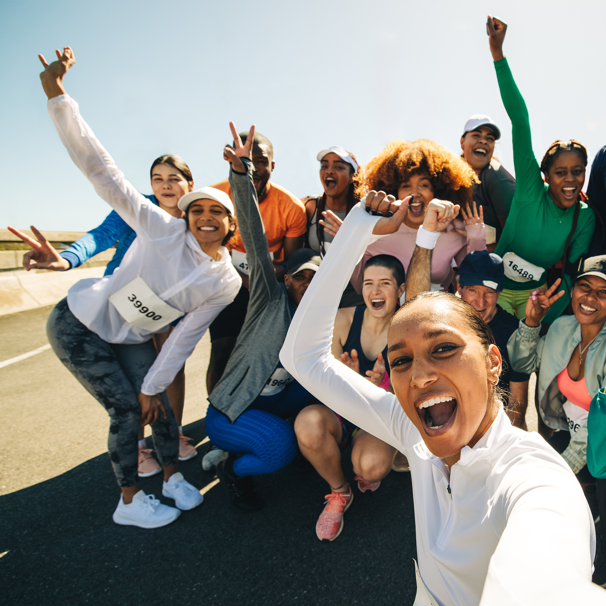 Group of people posing energetically on a road with clear sky