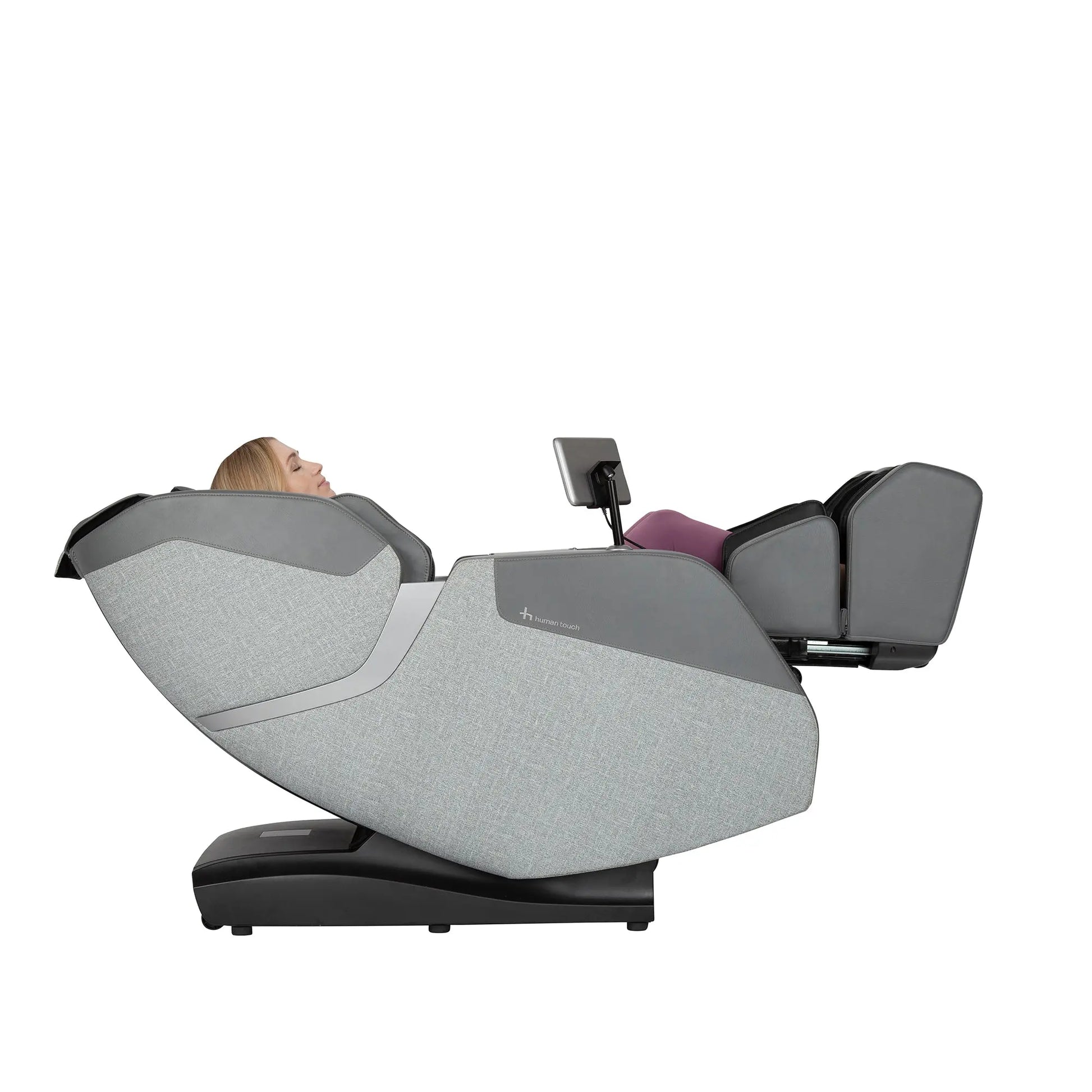 A woman using the WholeBody® ROVE Massage Chair by Human Touch® with the calf and foot massager extended on a white