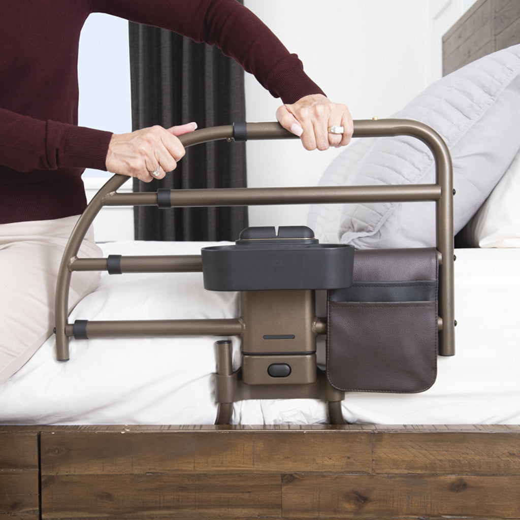 Person using a bed rail in a bedroom setting