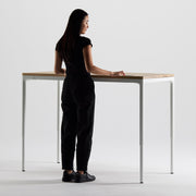 Woman standing at a modern standing desk with a minimalist design.