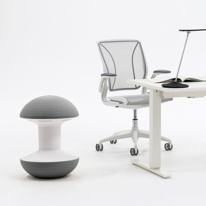 The Ballo Active Stool in front of a white top and and white base standing desk.