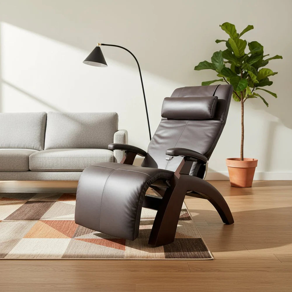 Dark brown leather recliner in a modern living room with a floor lamp, light sofa, and potted plant.