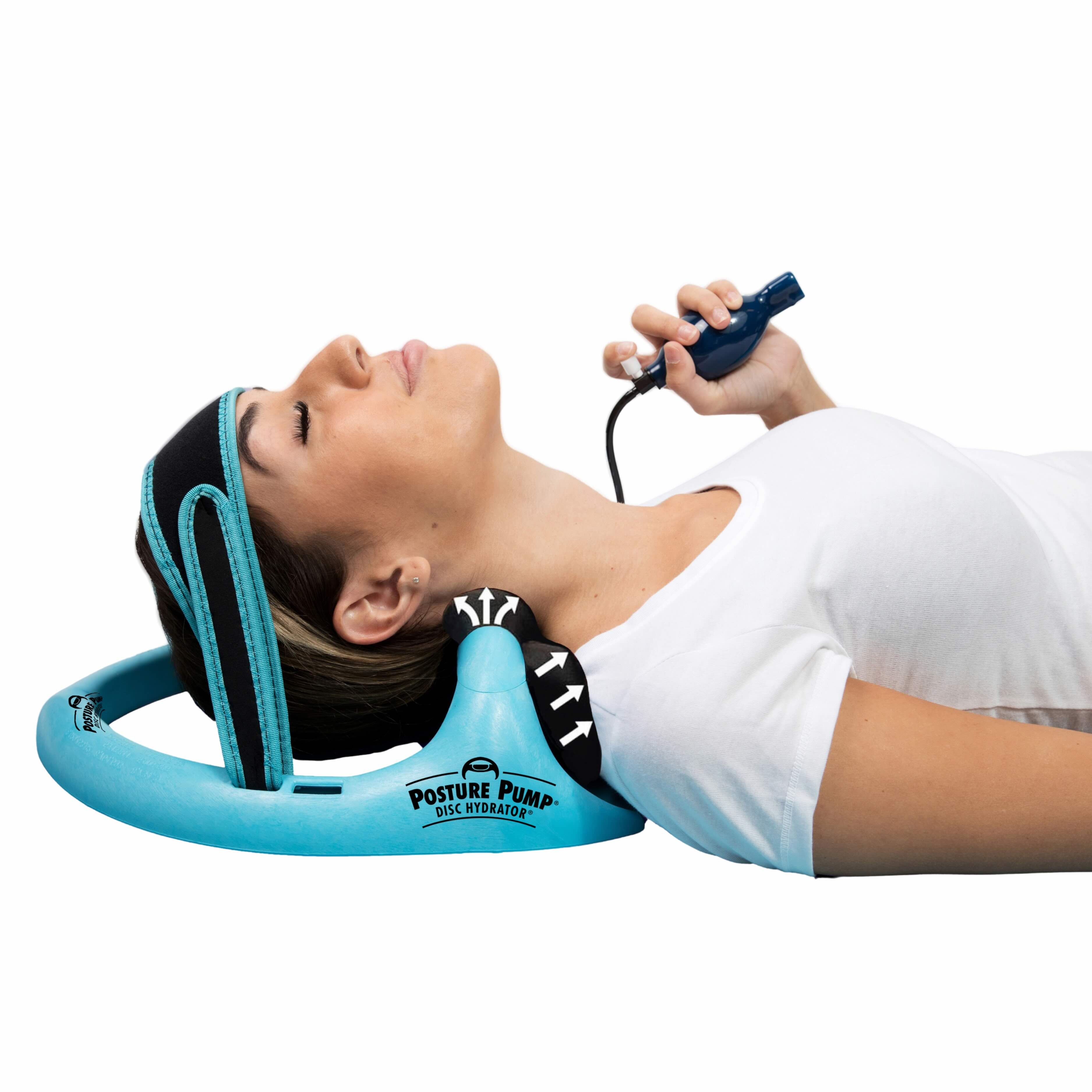 A woman lying down using the Posture Pump Hydration neck decompression device, which is light blue with black padding, while holding a blue control wand.
