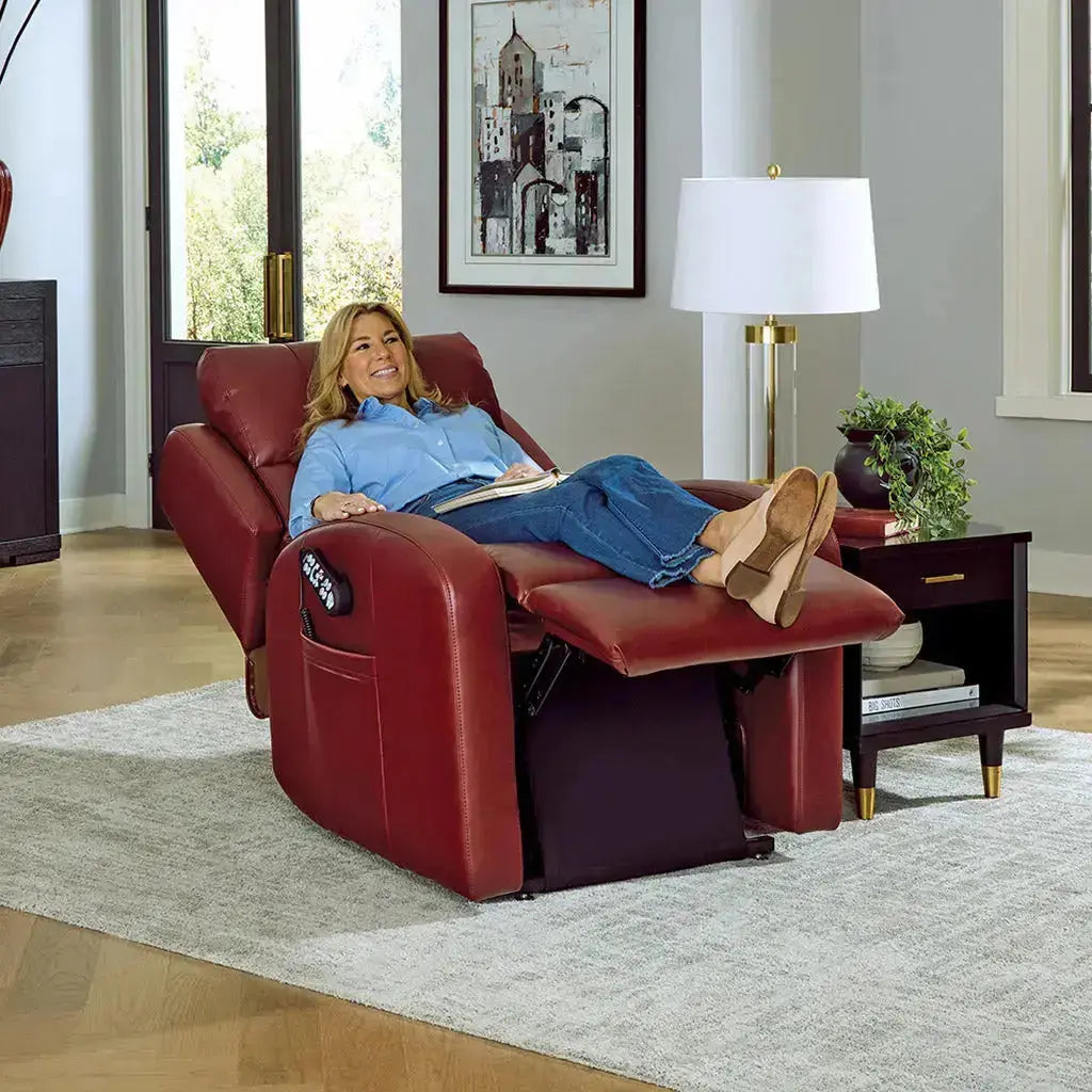 Woman relaxing in a red Sunrise PR134 Zero Gravity Lift Recliner in a modern living room, with legs elevated and remote control visible on armrest