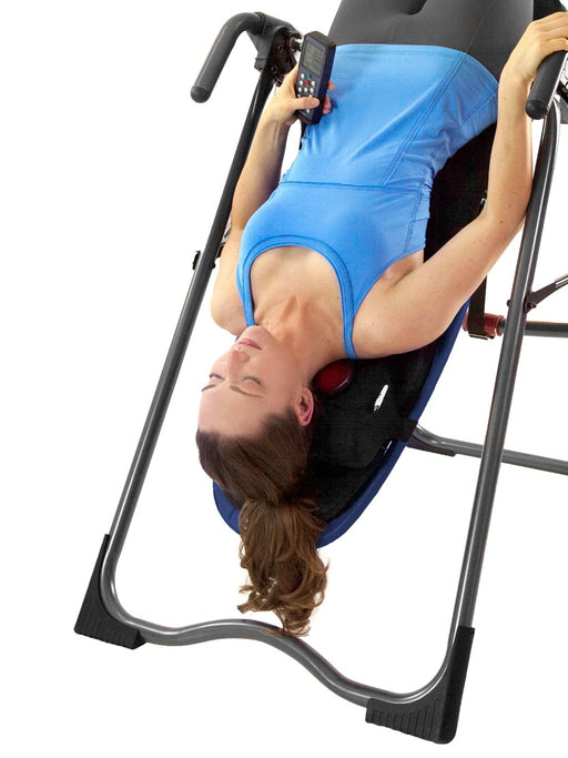 Women using the better back vibration cushion on a teeter inversion table inverted 
