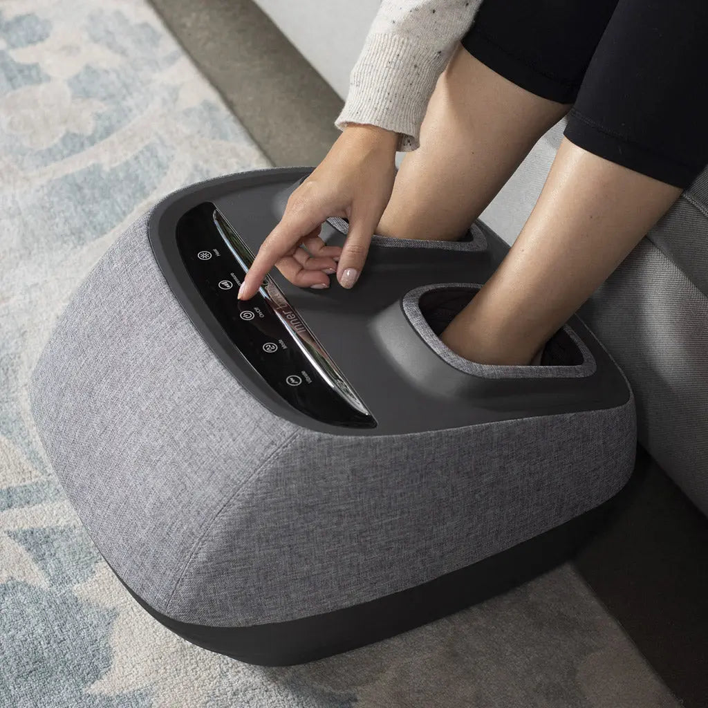 A woman using the Arch Refresh Foot Massager.